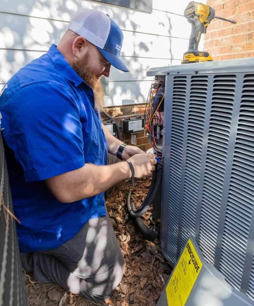HVAC technician opening the service panel on a condenser